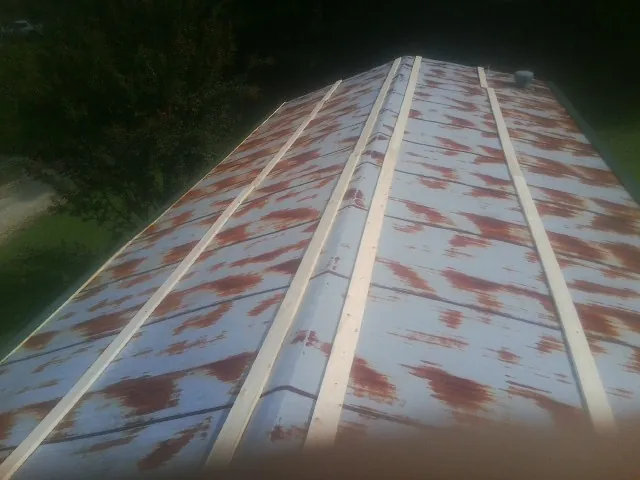 Rusted metal roof panels with new wood purlins before replacement — Storm Damage Roof Repair in Lorain by Roofing Brothers