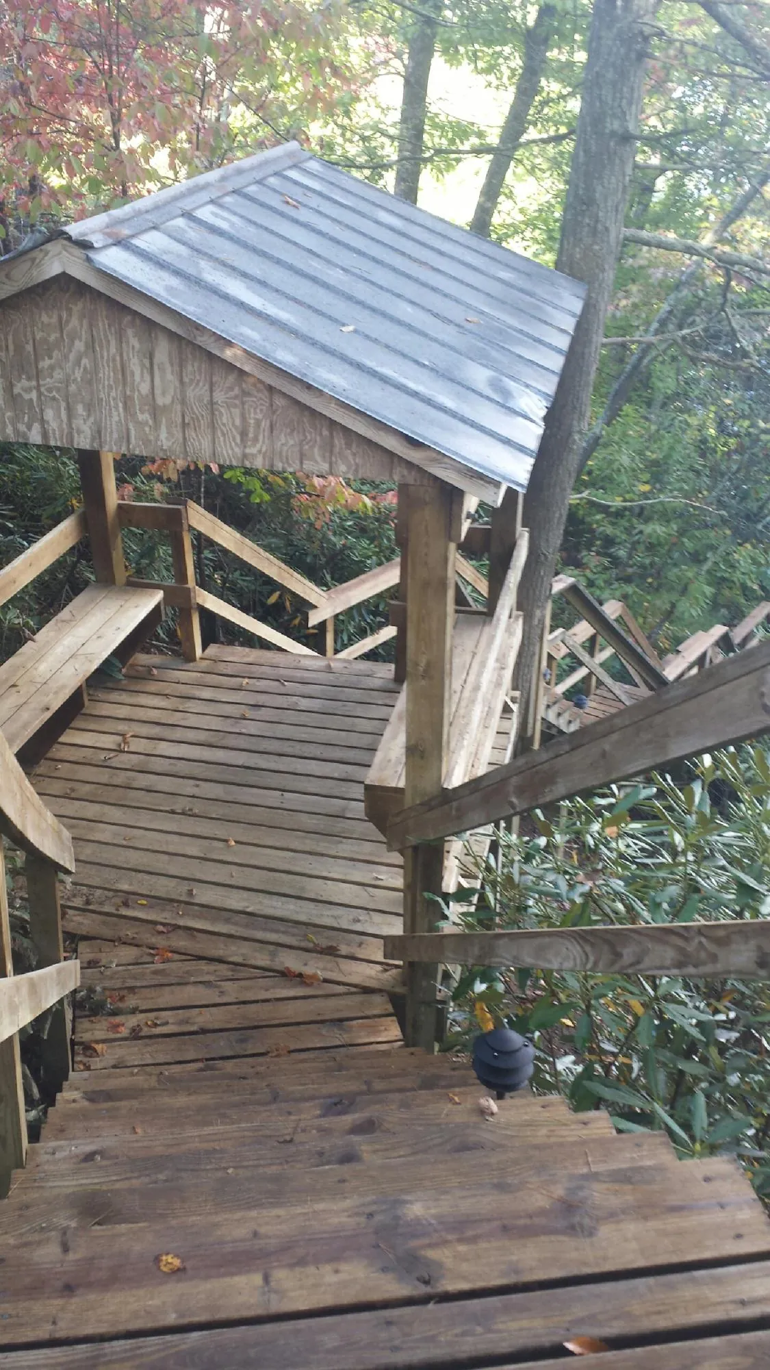 Metal roofed shelter over wooden steps on a wooded walkway — Skylight Repair & Installation work by our crew in Lorain