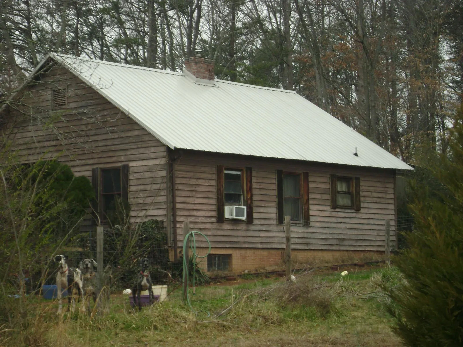 White metal roof on an old wood sided farmhouse, from a Metal Roof Installation job in Lorain